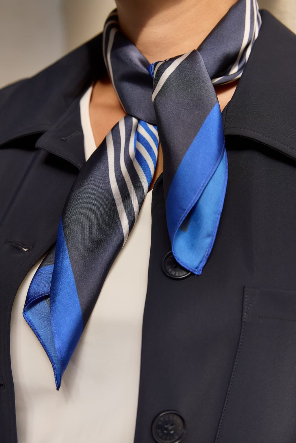 Zijden sjaal in navy en blauw gedragen bij een donkerblauwe blazer